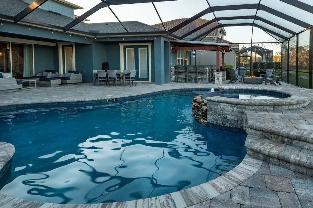 Paver deck and pergola outdoor kitchen — Backyard Oasis custom pool project by Wahoo Pools in Tampa Bay, FL
