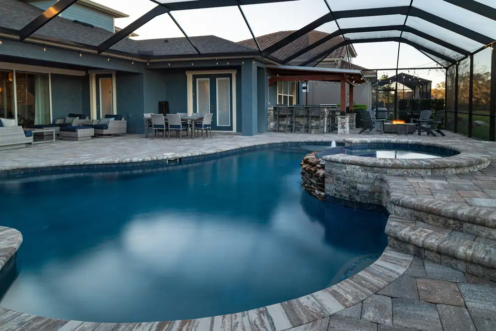 Screened enclosure at dusk — Backyard Oasis custom pool project by Wahoo Pools in Tampa Bay, FL