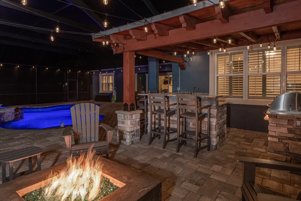 Pool at night with screen enclosure — Backyard Oasis custom pool project by Wahoo Pools in Tampa Bay, FL