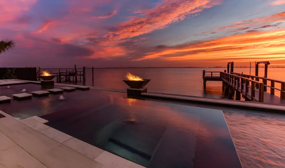 Black-tile reflecting pool at sunset — Sandpiper Bayfront custom pool project by Wahoo Pools in Tampa Bay bayfront