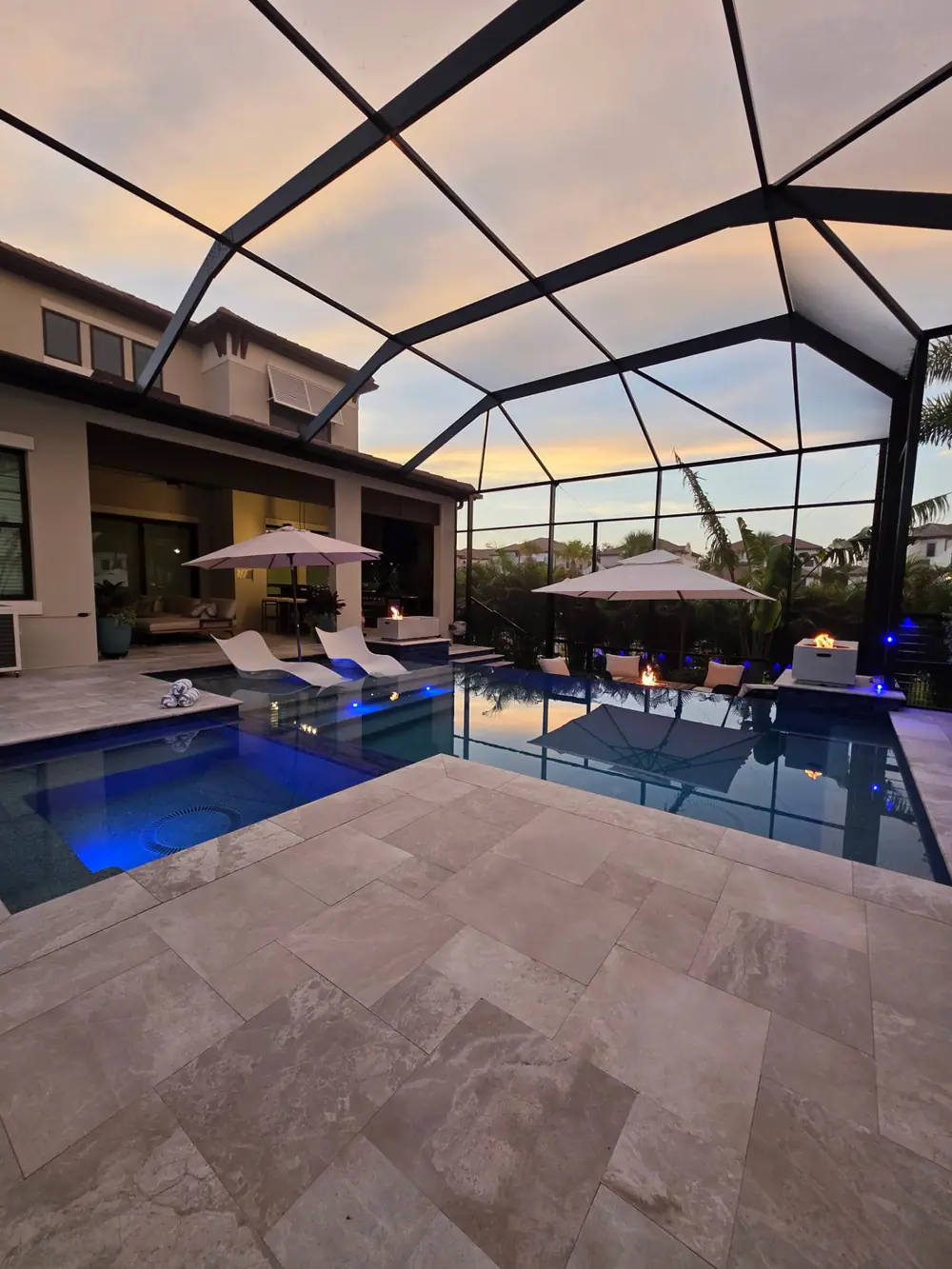 Sunset Lanai Retreat — screened pool and spa with fire bowls at sunset — Wahoo Pools project in Tampa, FL