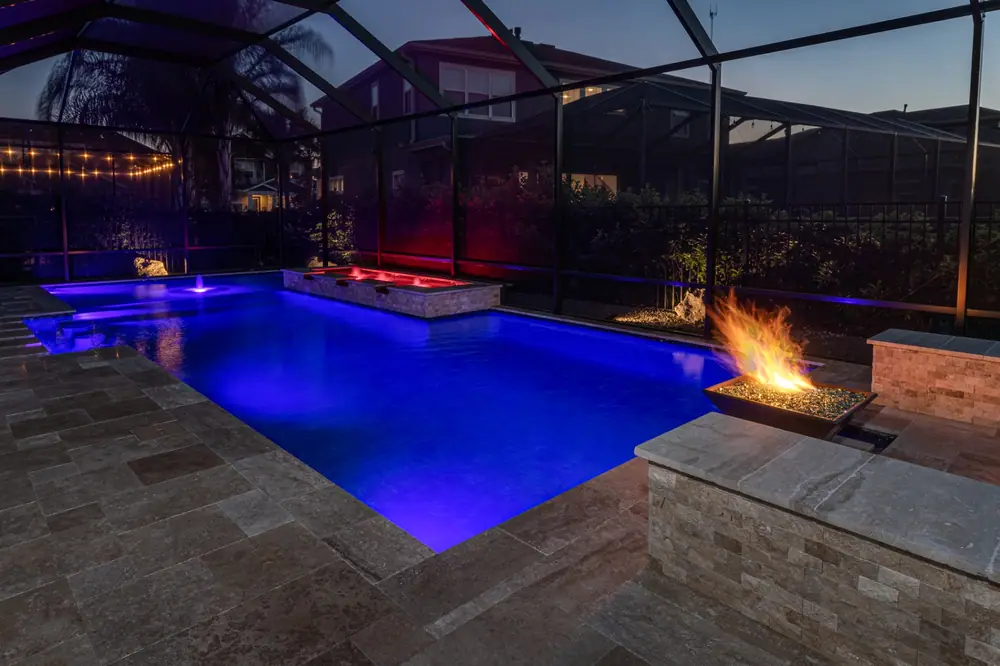 Freeform pool glowing at night — Tequila Sunrise custom pool project by Wahoo Pools in Tampa Bay, FL