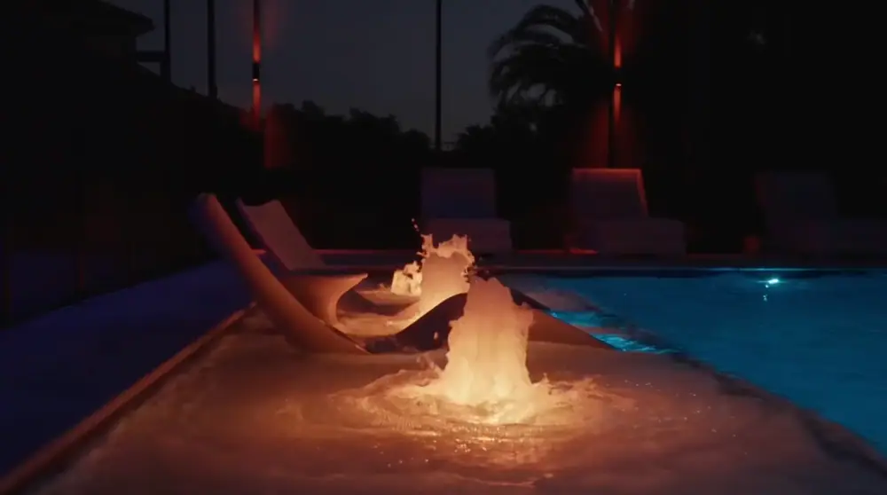 Twilight Lanai Estate — warm-lit bubblers on the tanning ledge at night — Wahoo Pools project in Tampa, FL