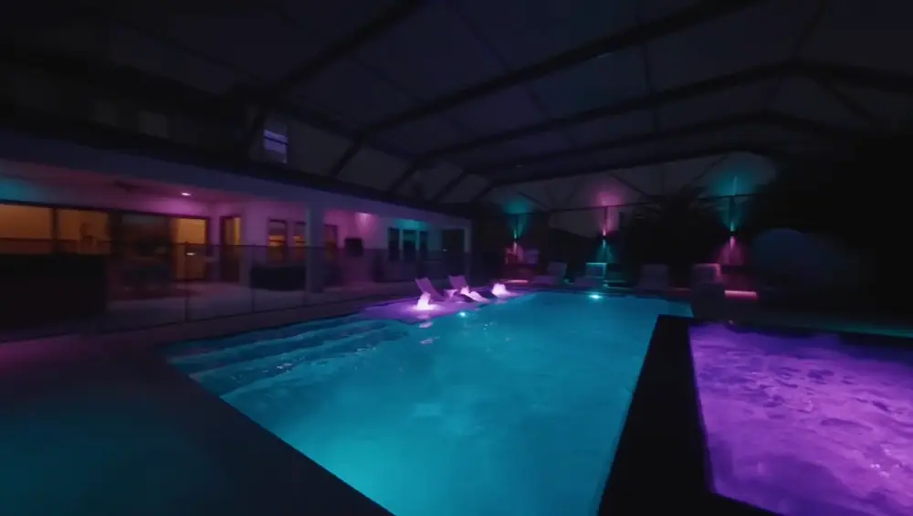 Twilight Lanai Estate — pool glowing teal and purple with LED color lighting — Wahoo Pools project in Tampa, FL