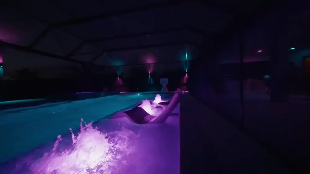 Twilight Lanai Estate — bubblers and spa spillway lit purple after dark — Wahoo Pools project in Tampa, FL