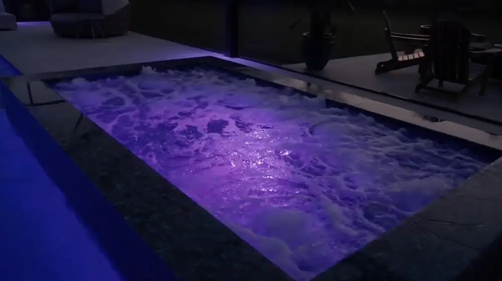 Twilight Lanai Estate — raised spa with jets running under purple LED light — Wahoo Pools project in Tampa, FL