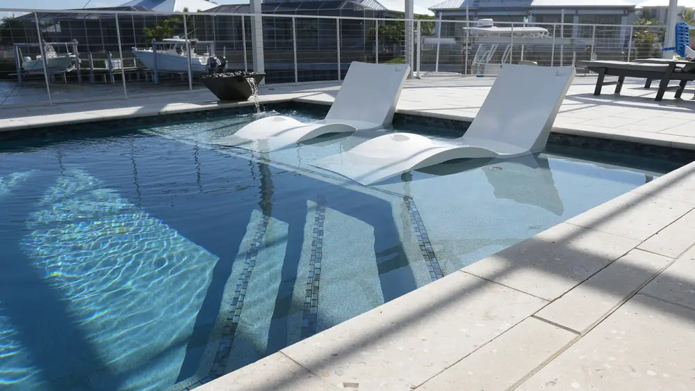 In-water ledge loungers — Vera Canal Retreat custom pool project by Wahoo Pools in Apollo Beach, FL
